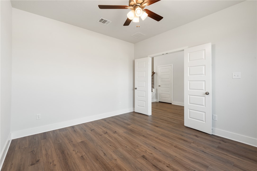 8452 Muir Wood Loop Anderson, TX 77830 - Photo 6 of 48 a view of an empty room with wooden floor