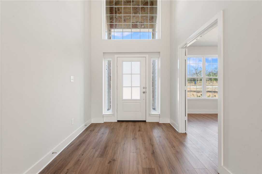 8452 Muir Wood Loop Anderson, TX 77830 - Photo 7 of 48 an empty room with wooden floor and windows