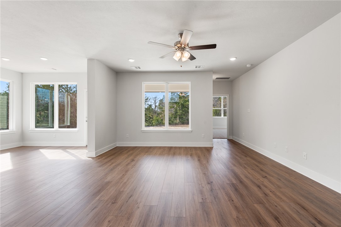 8452 Muir Wood Loop Anderson, TX 77830 - Photo 8 of 48 a view of an empty room with wooden floor and a window