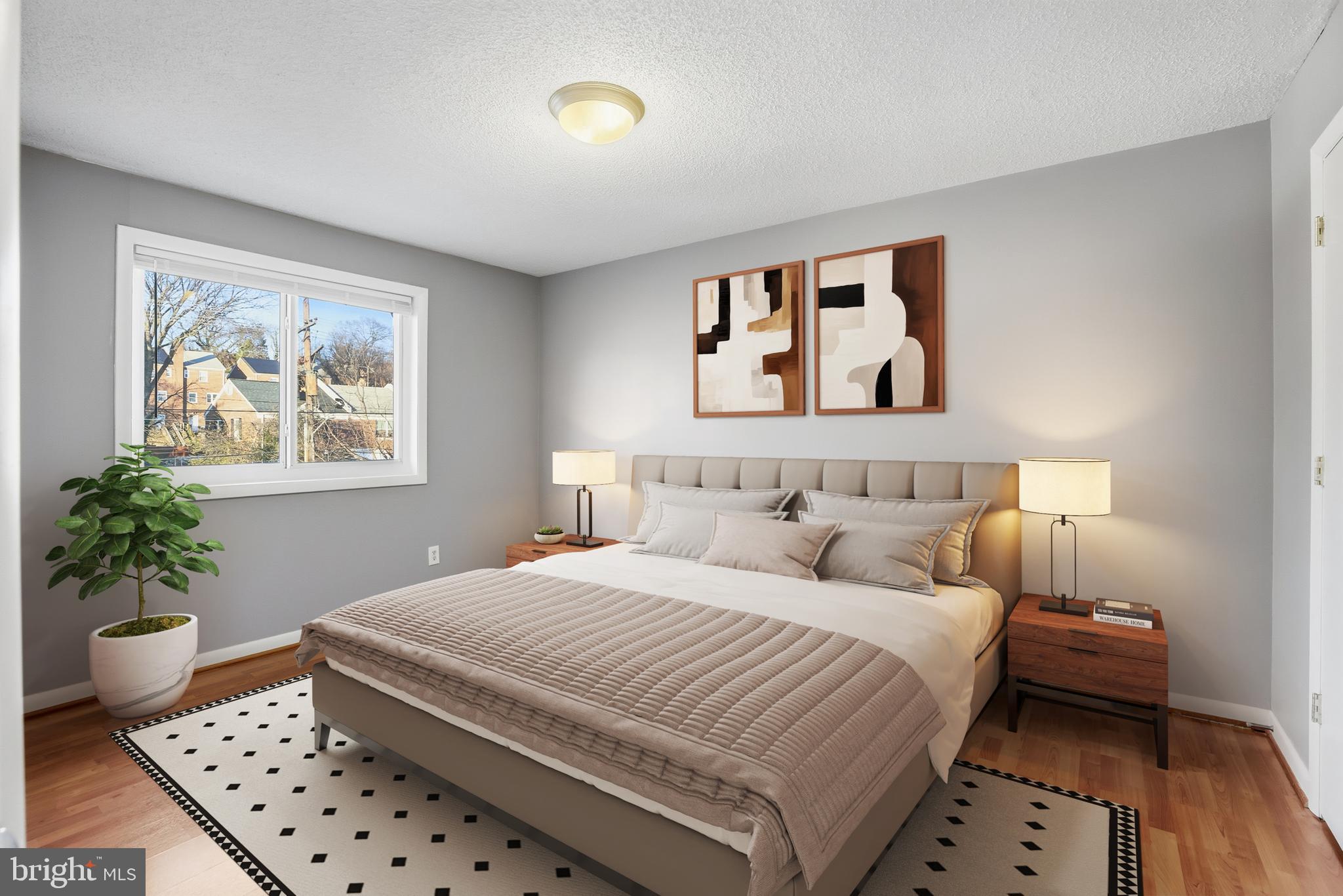 625 Chesapeake Street Southeast, Unit 301 Washington, DC 20032 - Photo 11 of 23 a bedroom with a large bed and a potted plant