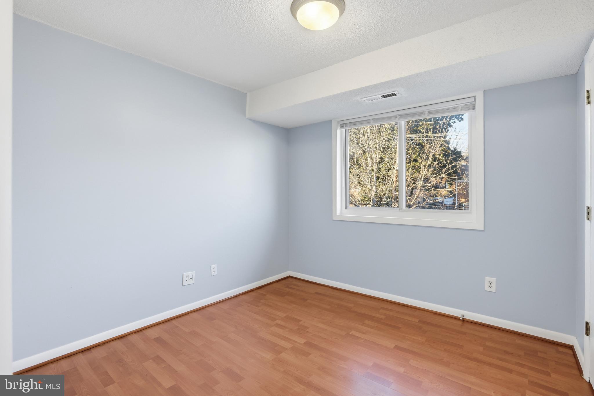 625 Chesapeake Street Southeast, Unit 301 Washington, DC 20032 - Photo 12 of 23 an empty room with wooden floor and windows
