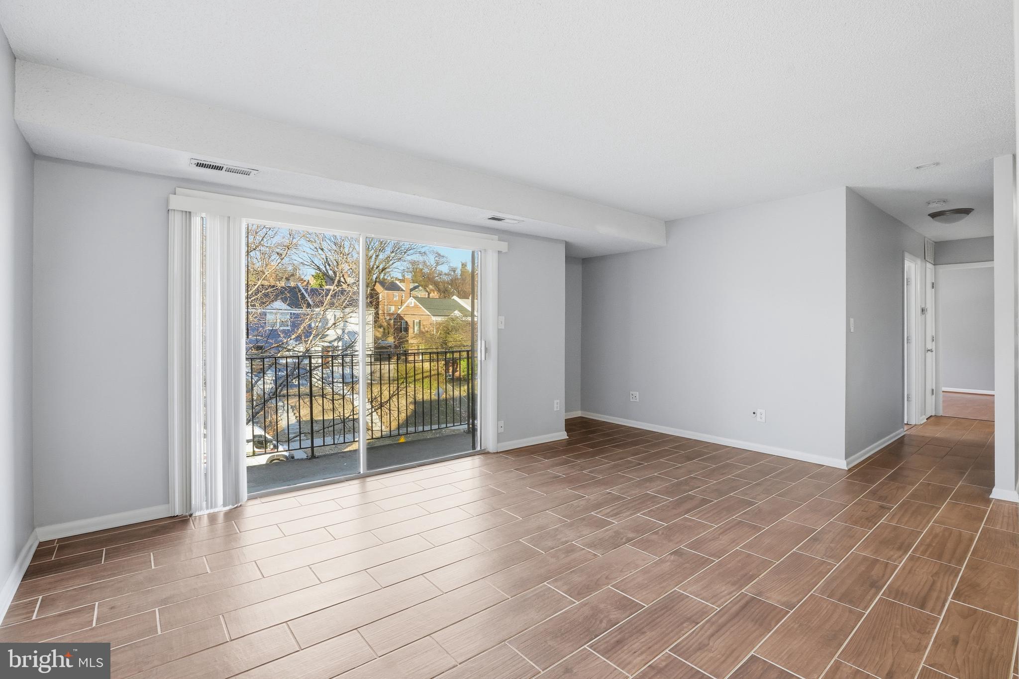 625 Chesapeake Street Southeast, Unit 301 Washington, DC 20032 - Photo 3 of 23 a view of an empty room with wooden floor and a window