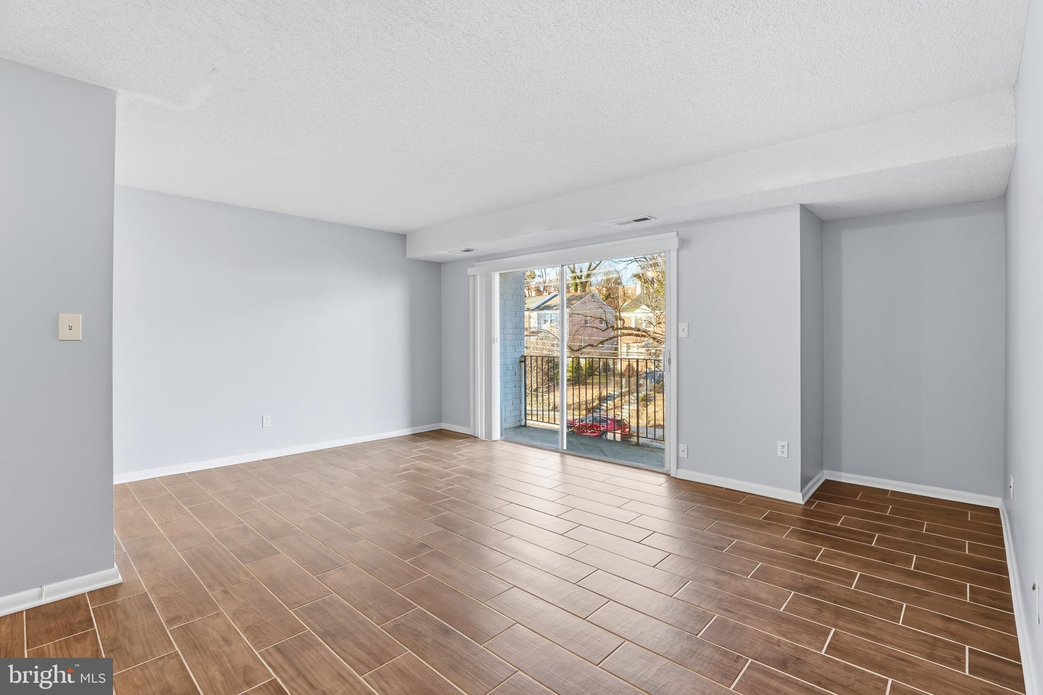 625 Chesapeake Street Southeast, Unit 301 Washington, DC 20032 - Photo 6 of 23 a view of an empty room with a window and wooden floor