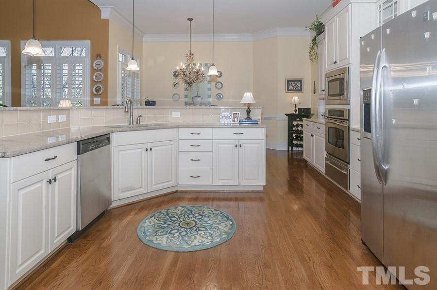 3317 Canoe Brook Parkway Raleigh, NC 27614 - Photo 28 of 67 a kitchen with stainless steel appliances granite countertop a sink dishwasher and white cabinets with wooden floor