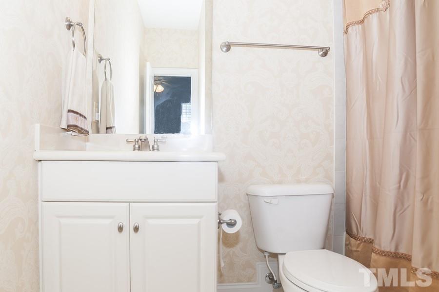 3317 Canoe Brook Parkway Raleigh, NC 27614 - Photo 45 of 67 a bathroom with a toilet a sink and a mirror