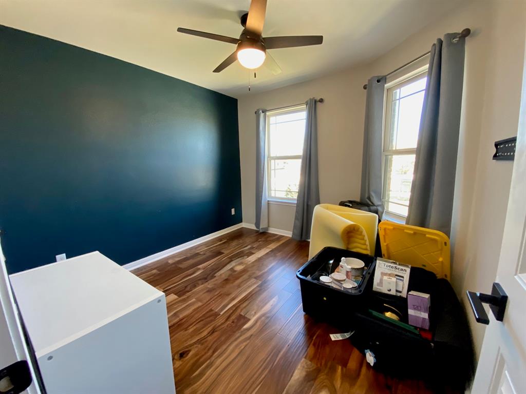 149 Red Sun Drive Kyle, TX 78640 - Photo 12 of 18 a bedroom with a bed and wooden floor