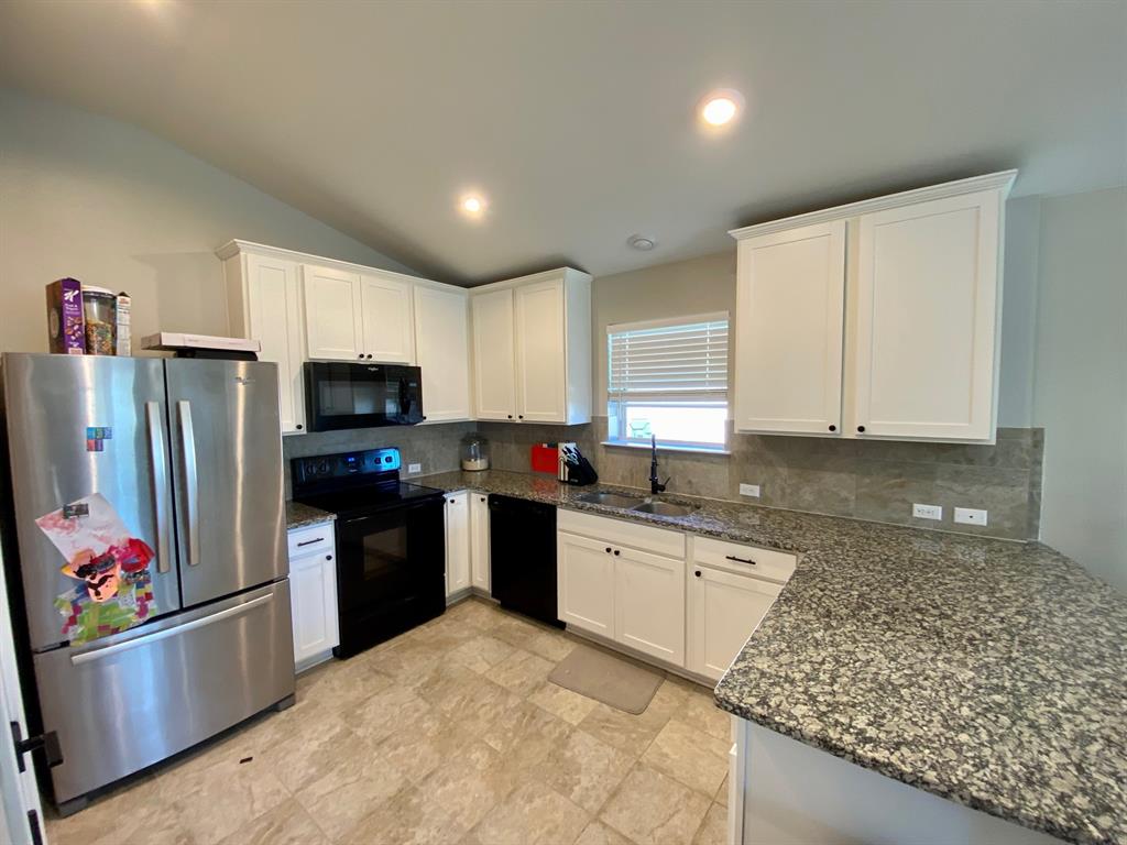 149 Red Sun Drive Kyle, TX 78640 - Photo 5 of 18 a kitchen with granite countertop a refrigerator and a sink