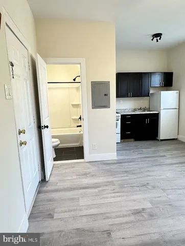 a view of a kitchen with a sink a refrigerator and a stove top oven