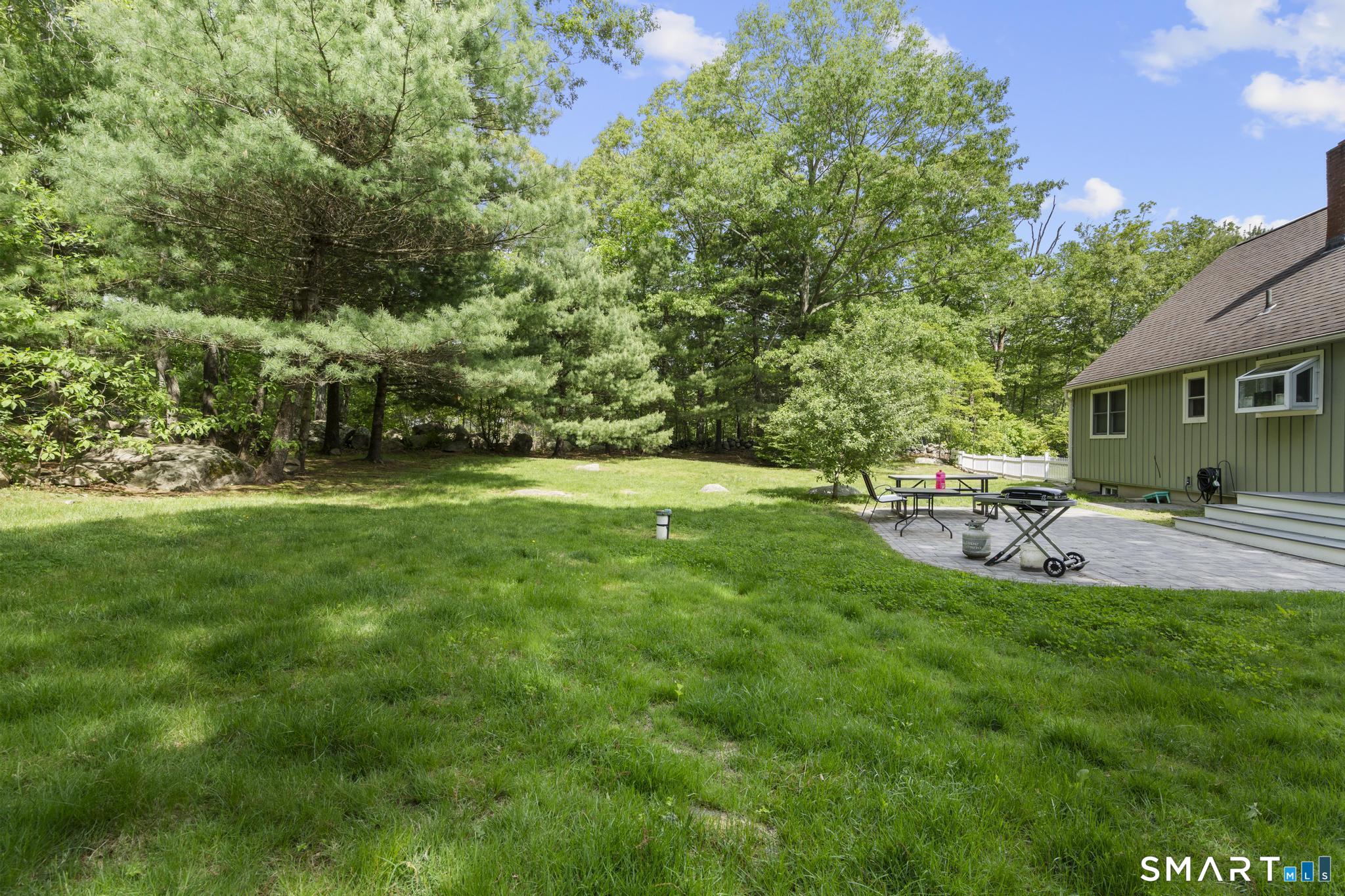 13 Christy Hill Road Ledyard, CT 06335 - Photo 34 of 38 a view of a patio with table and chairs and potted plants and large trees