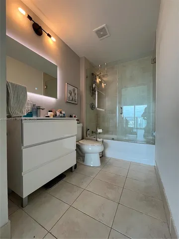 a bathroom with a double vanity sink toilet and mirror