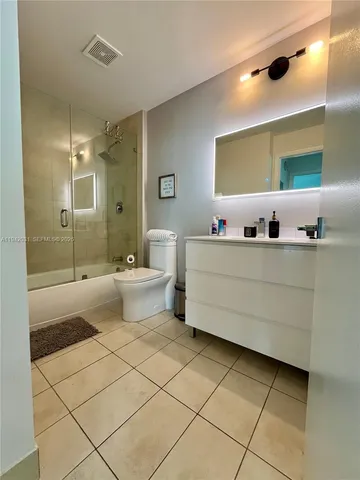 a bathroom with a double vanity sink mirror and toilet
