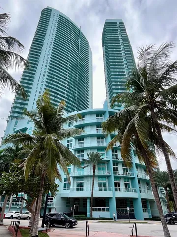 a front view of a building with streets and trees