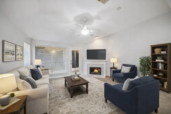 a living room with furniture a fireplace and a flat screen tv