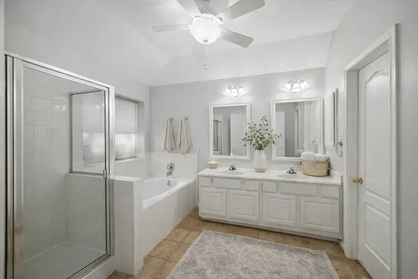 a spacious bathroom with a double vanity sink a mirror and a bathtub