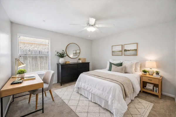 a bedroom with a bed a table and chair