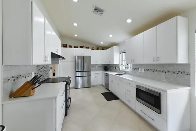 a kitchen with stainless steel appliances a refrigerator sink and microwave