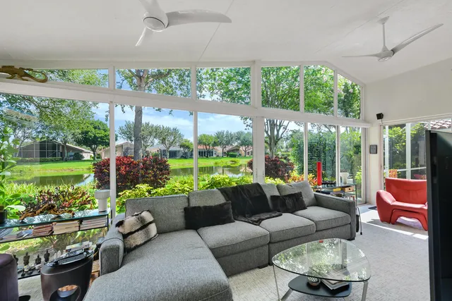 a view of a lake with a big yard and potted plants and large trees