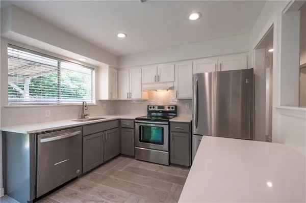 a kitchen with stainless steel appliances granite countertop a refrigerator sink and stove