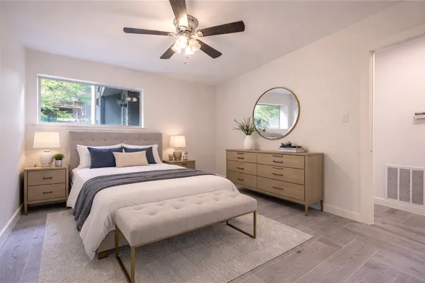 a bedroom with a bed a chandelier and a dresser