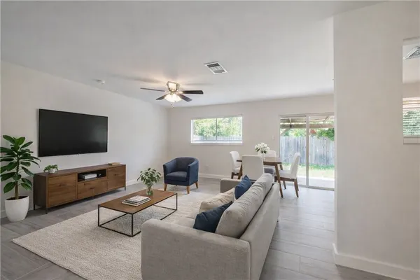a living room with furniture a flat screen tv and a window