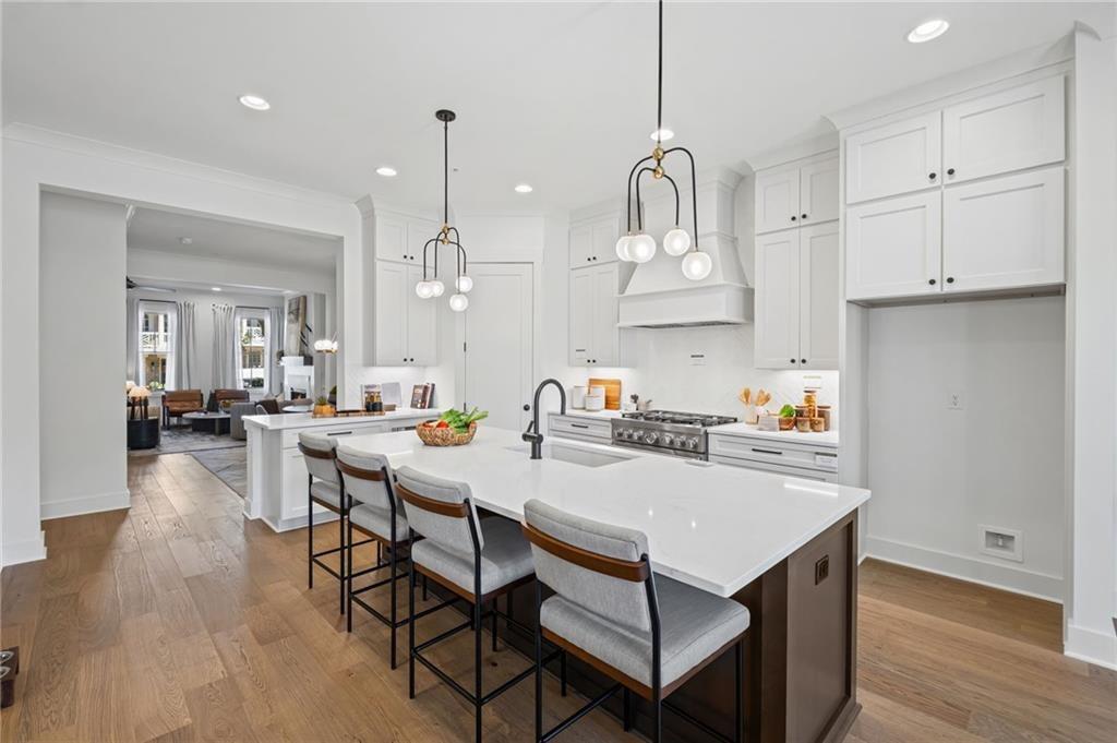 3440 Commander Cove Suwanee, GA 30024 - Photo 14 of 49 a kitchen with stainless steel appliances granite countertop a kitchen island a stove a table and chairs in it