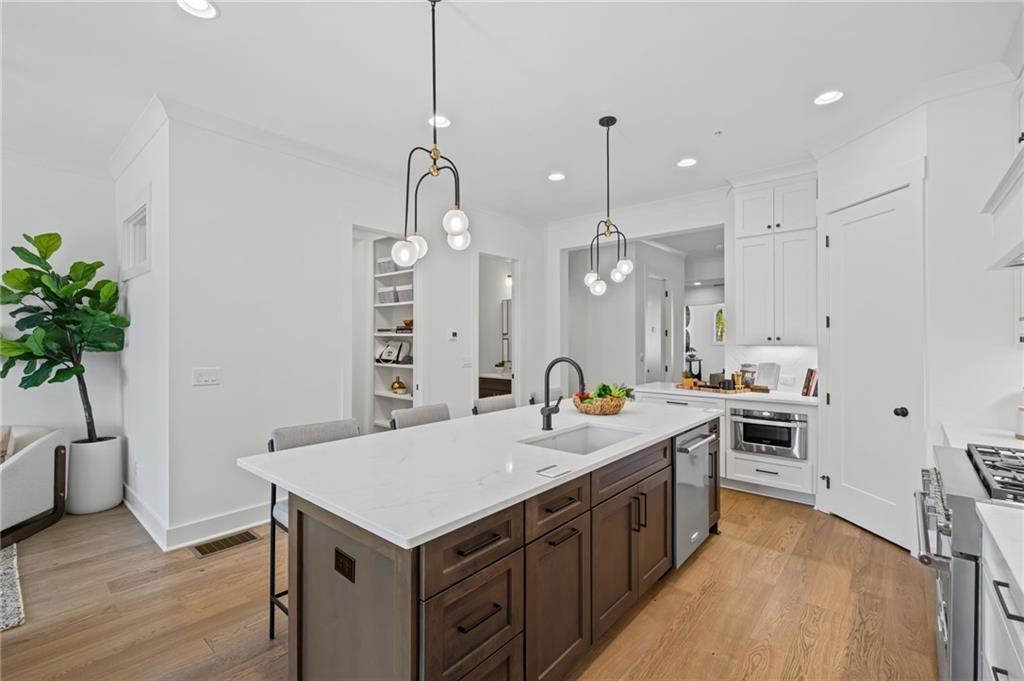 3440 Commander Cove Suwanee, GA 30024 - Photo 15 of 49 a kitchen with a sink a counter top space stainless steel appliances and wooden floor