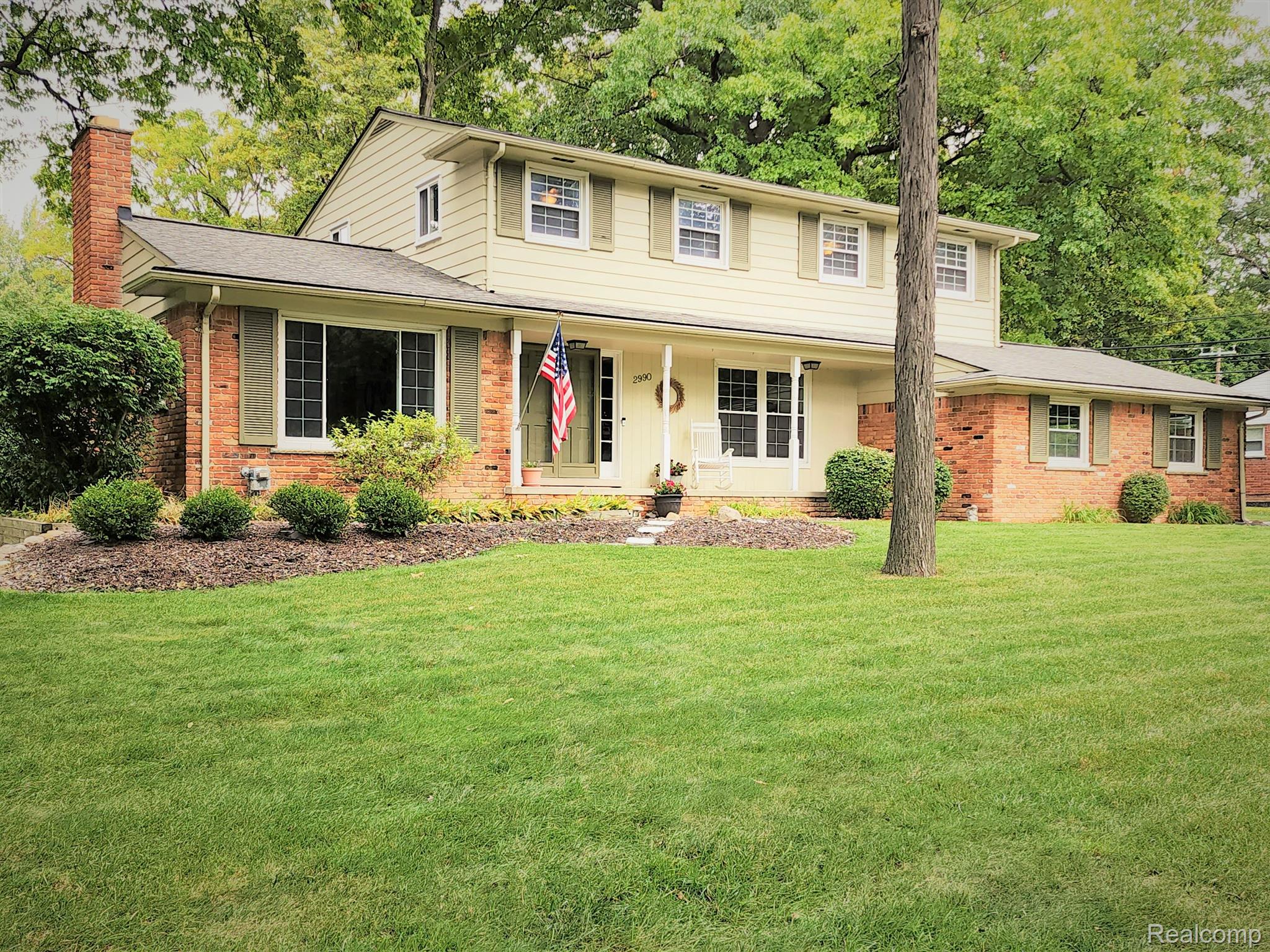 Front of home with large front yard & landscaping.