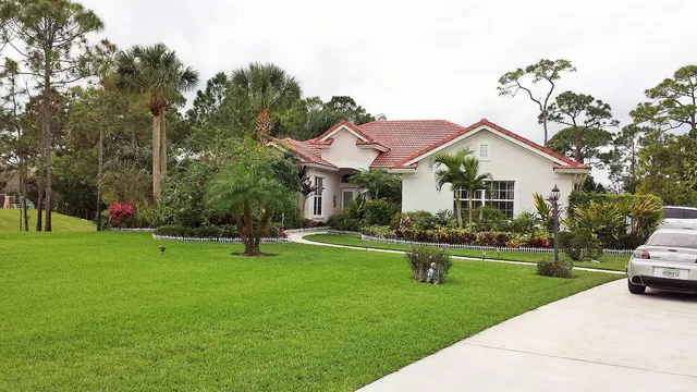 a front view of a house with a yard and trees