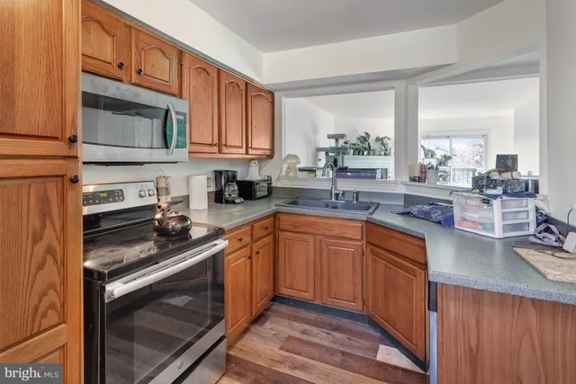 a kitchen with stainless steel appliances granite countertop a sink stove and cabinets