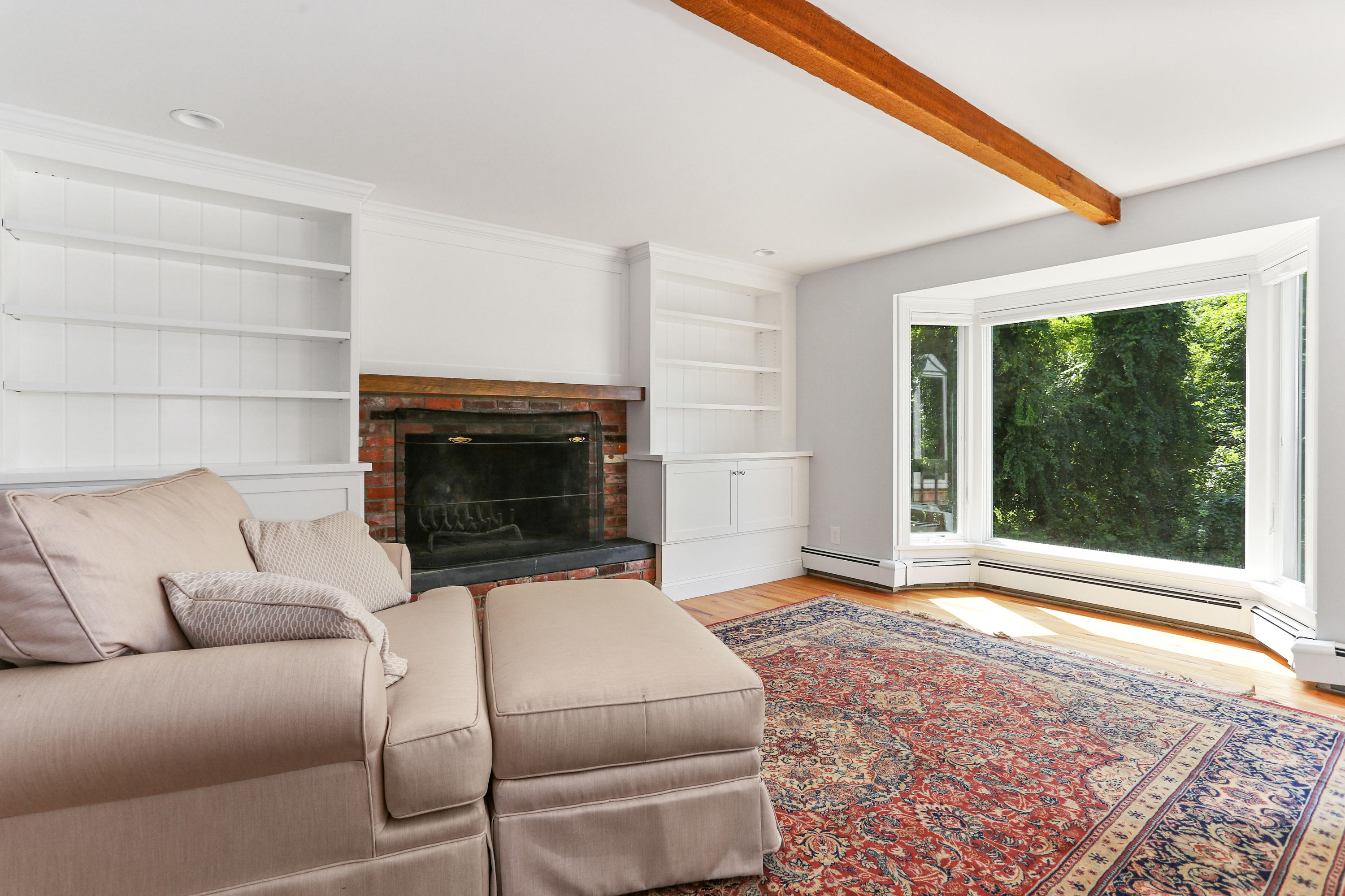 225 Goody Hallet Drive Eastham, MA 02642 - Photo 12 of 45 a living room with a couch a fireplace and a large window
