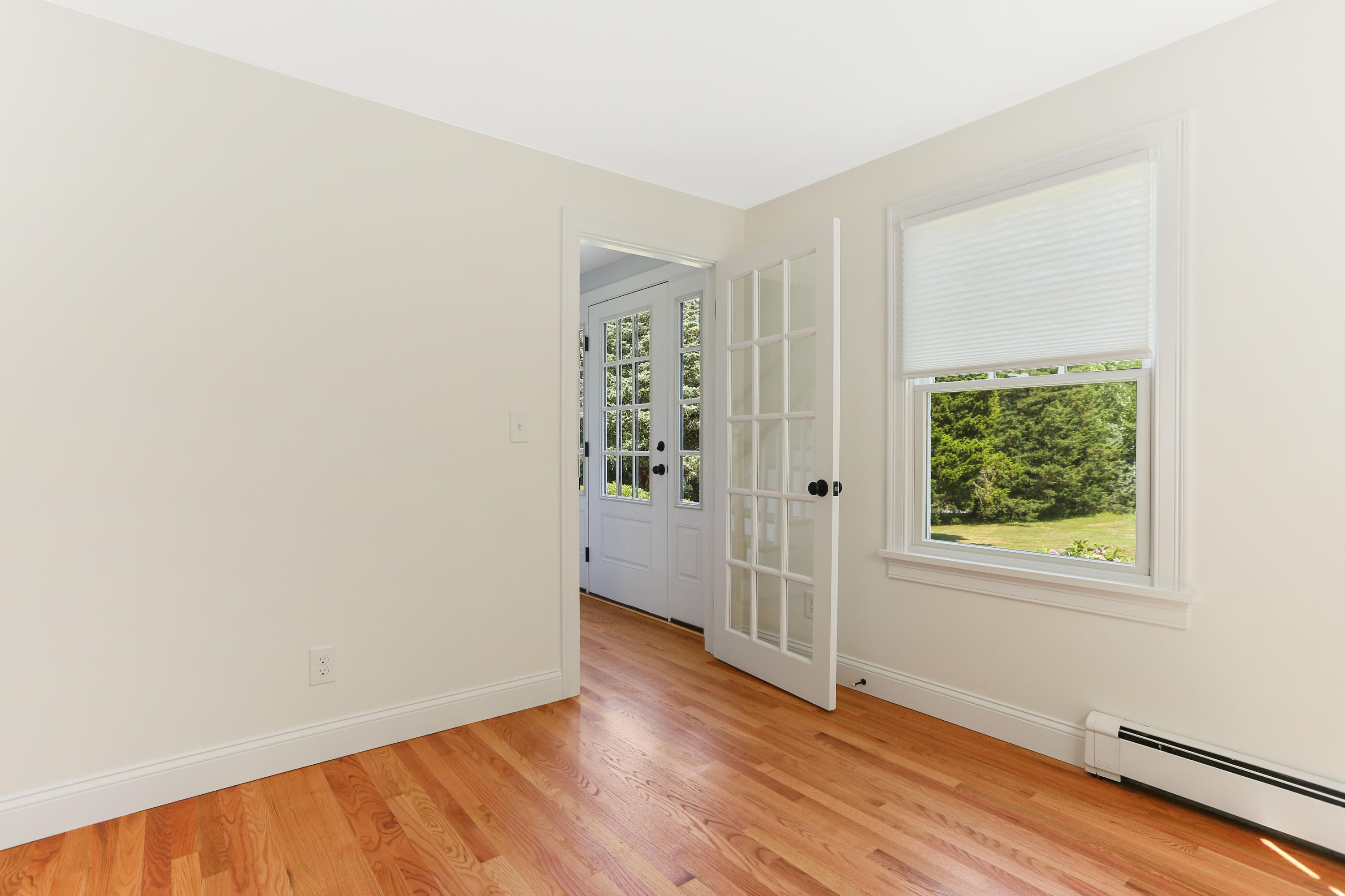 225 Goody Hallet Drive Eastham, MA 02642 - Photo 17 of 45 an empty room with wooden floor and windows
