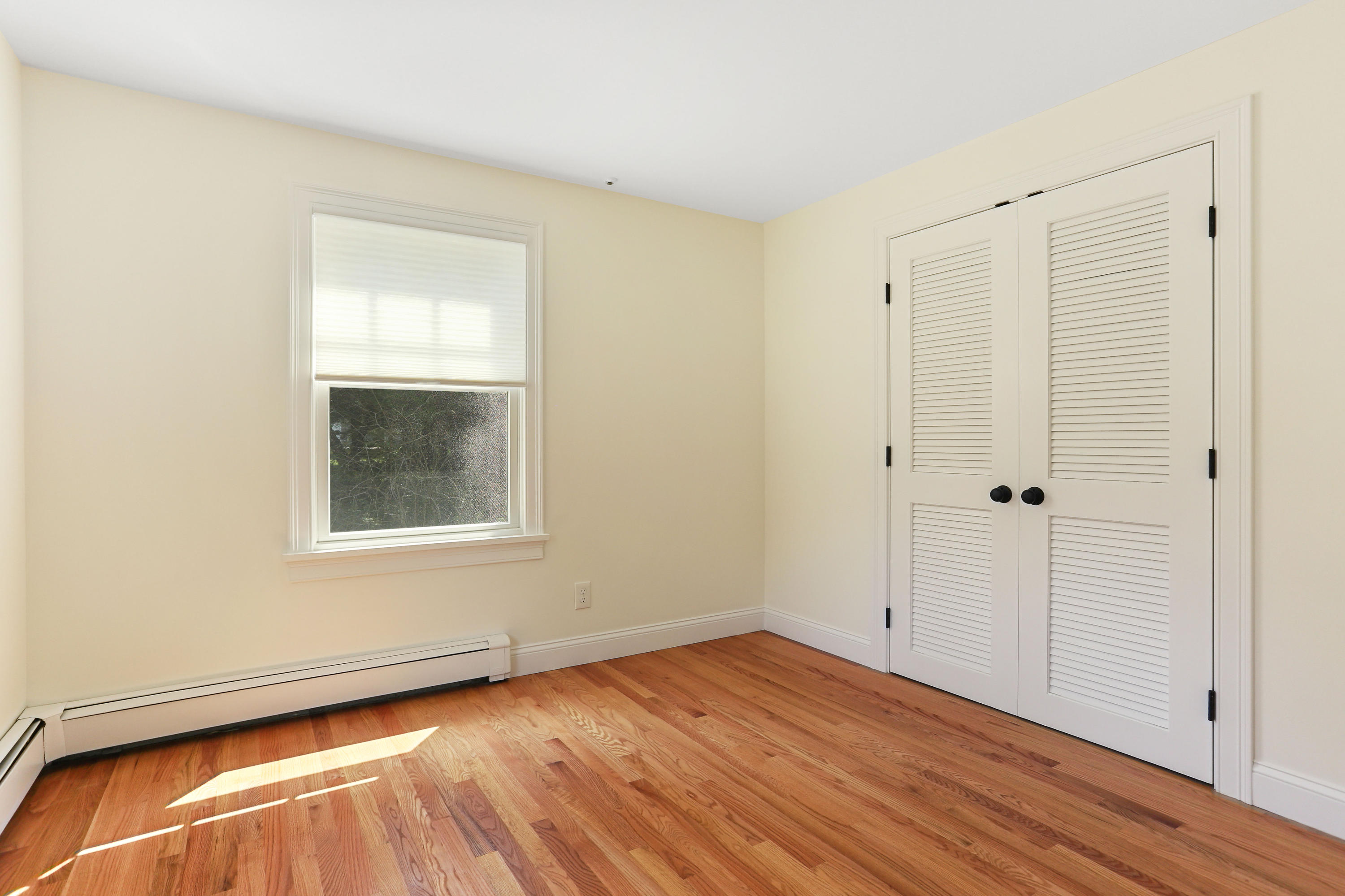 225 Goody Hallet Drive Eastham, MA 02642 - Photo 18 of 45 a view of an empty room with wooden floor and a window