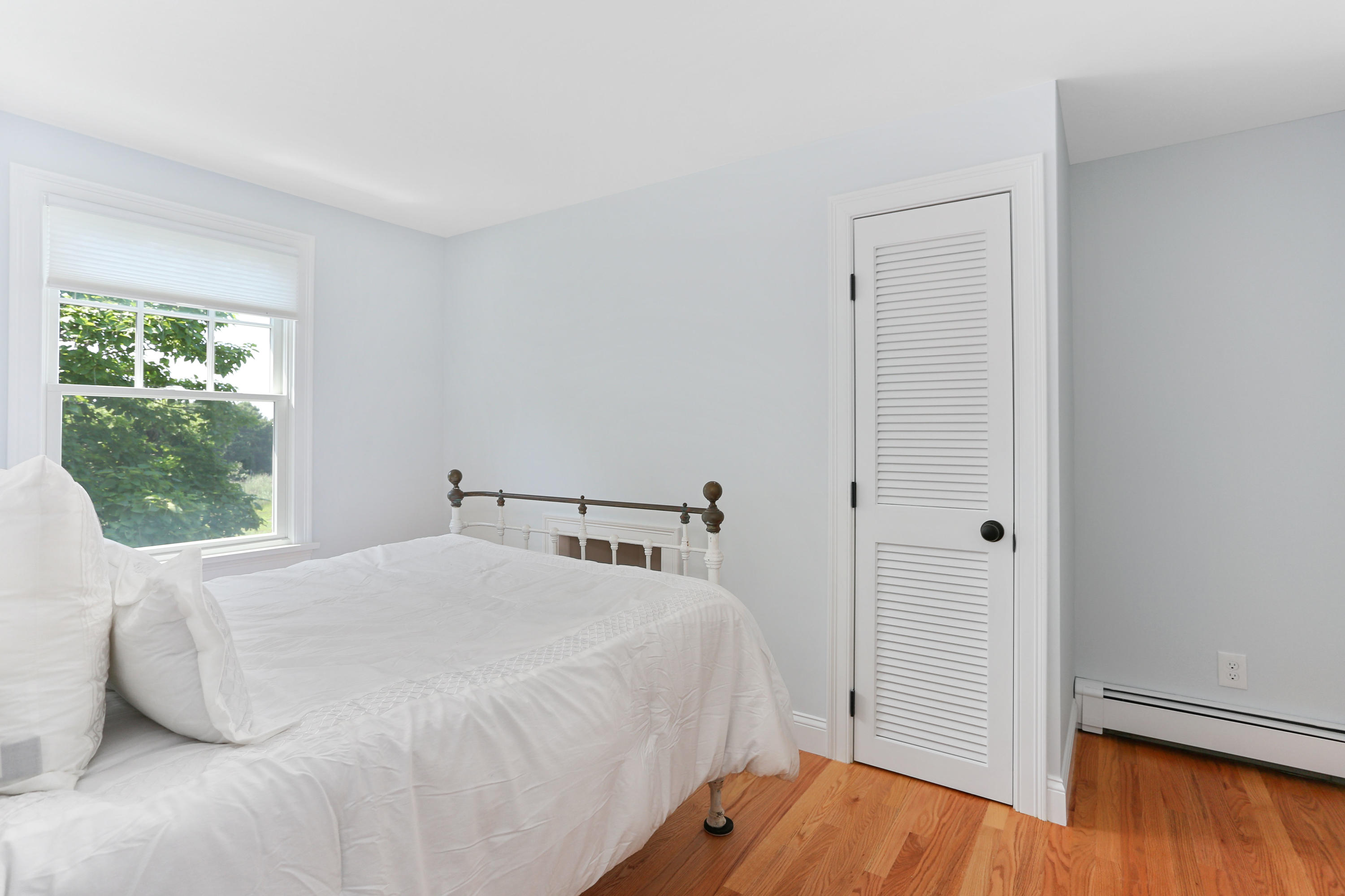 225 Goody Hallet Drive Eastham, MA 02642 - Photo 25 of 45 a bedroom with a bed and wooden floor