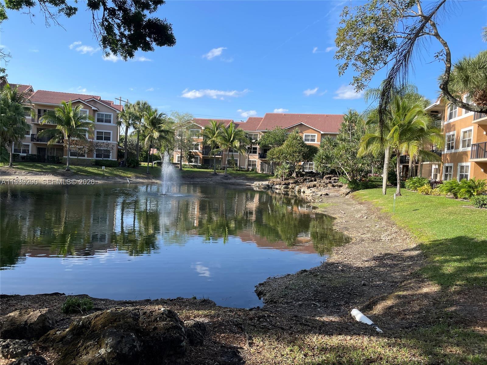 8821 Wiles Road, Unit 101 Coral Springs, FL 33067 - Photo 3 of 12 a lake view with palm trees