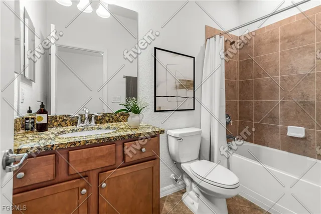 a bathroom with a granite countertop toilet sink and mirror