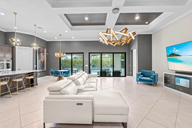 a large white kitchen with a large window and furniture