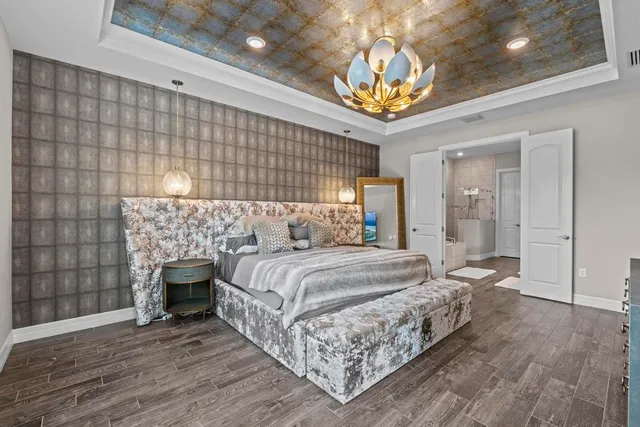 a spacious bedroom with a bed and a chandelier