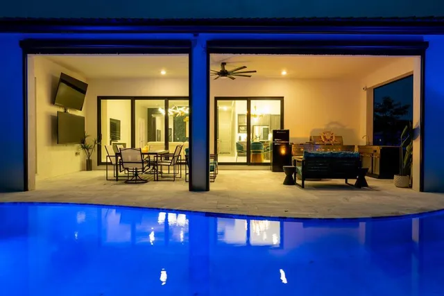 a living room with table chairs and a large window