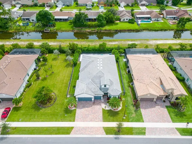 an aerial view of a house with a garden and lake view