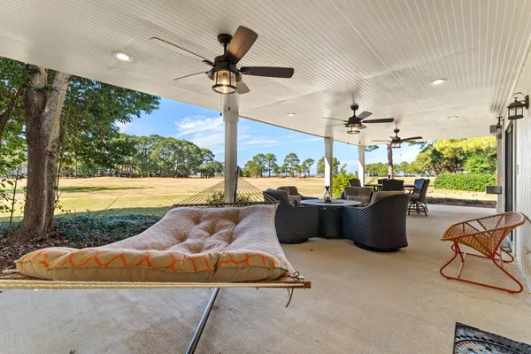 a living room with patio furniture and a floor to ceiling window
