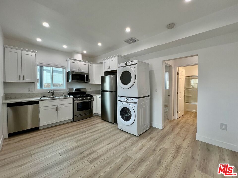 a kitchen with wooden floors stainless steel appliances
