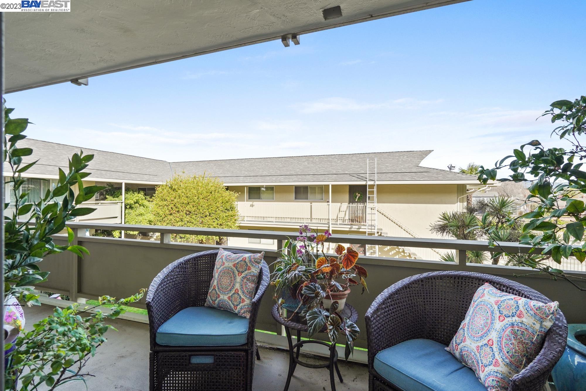 a view of a chairs and table in the balcony