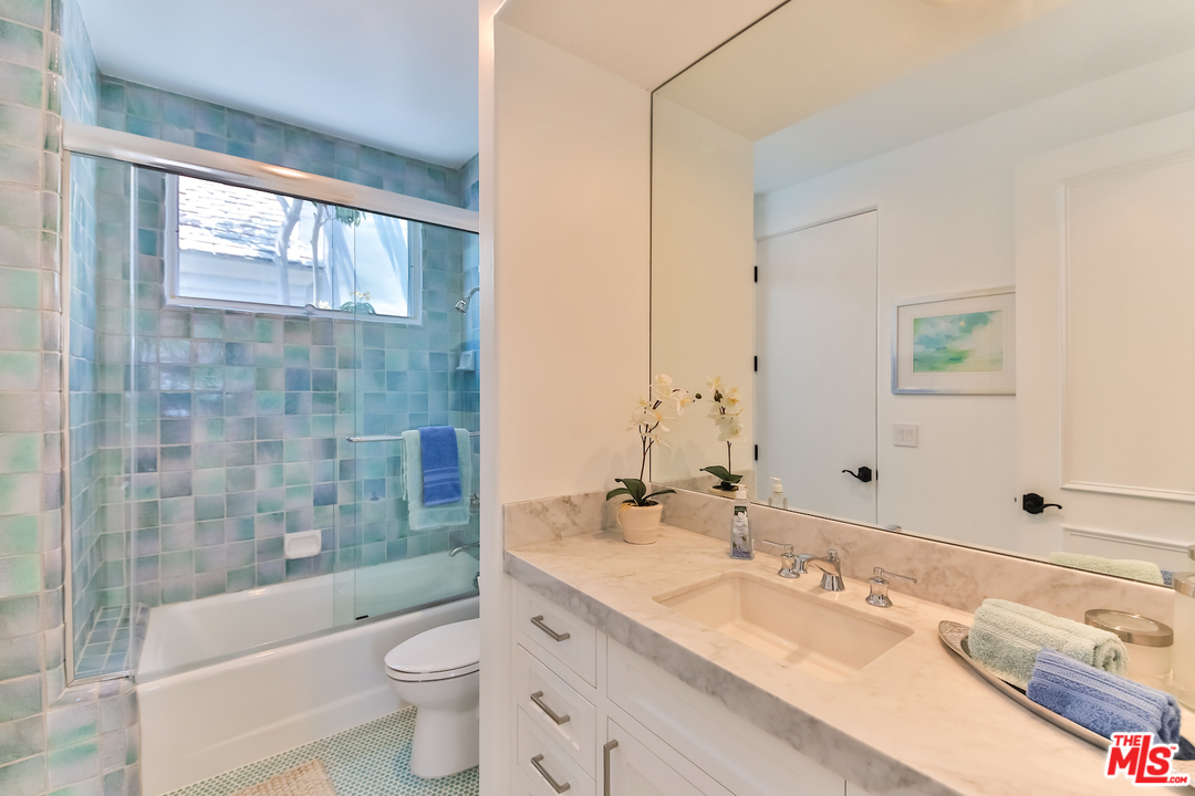 124 Reef Mall Marina del Rey, CA 90292 - Photo 33 of 44 a bathroom with a granite countertop sink a toilet a large mirror a bathtub and shower
