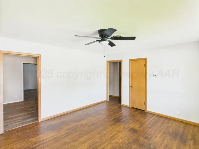 a view of an empty room with wooden floor