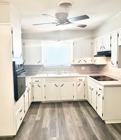 a white kitchen with granite countertop white cabinets and white appliances