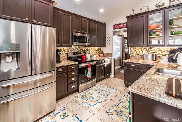 a kitchen with stainless steel appliances granite countertop a refrigerator stove and sink