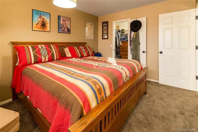 a bedroom with a bed and painting on the wall