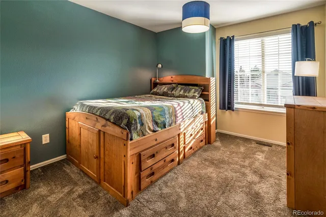 a bed sitting in a bedroom next to a window