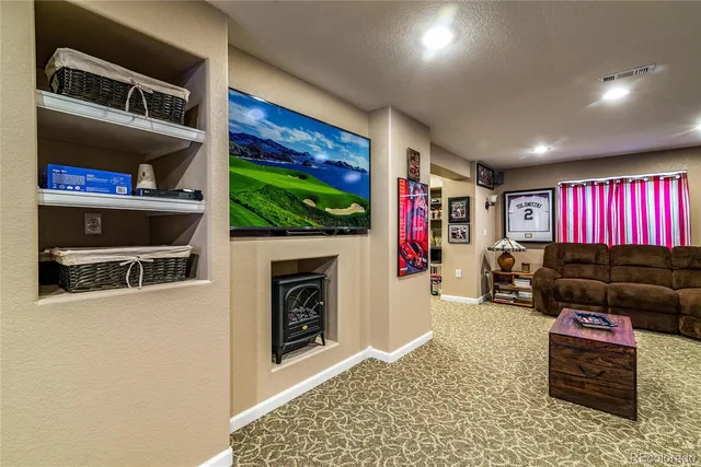 a living room with furniture a flat screen tv and a fireplace