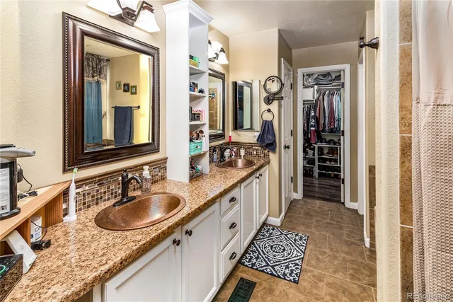 a bathroom with a sink double vanity granite tub shower and a mirror